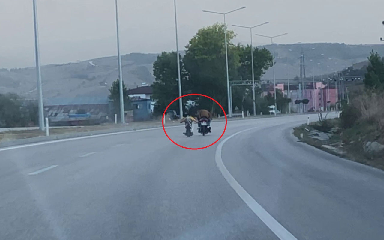 Motosiklet üstünde yatarak giden sürücü tehlike saçtı