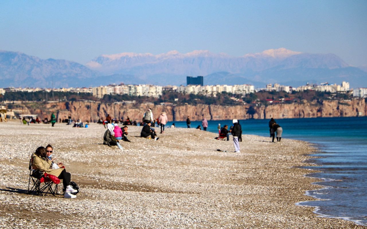 Antalya Konyaaltı Sahili'nde bugün: Zirvesi karla kaplı Toros Dağlarına karşı deniz keyfi
