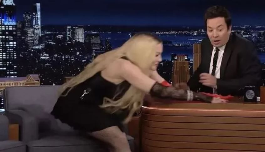 Madonna'dan şok hareket! Sırf kalçasını göstermek için masaya atladı!